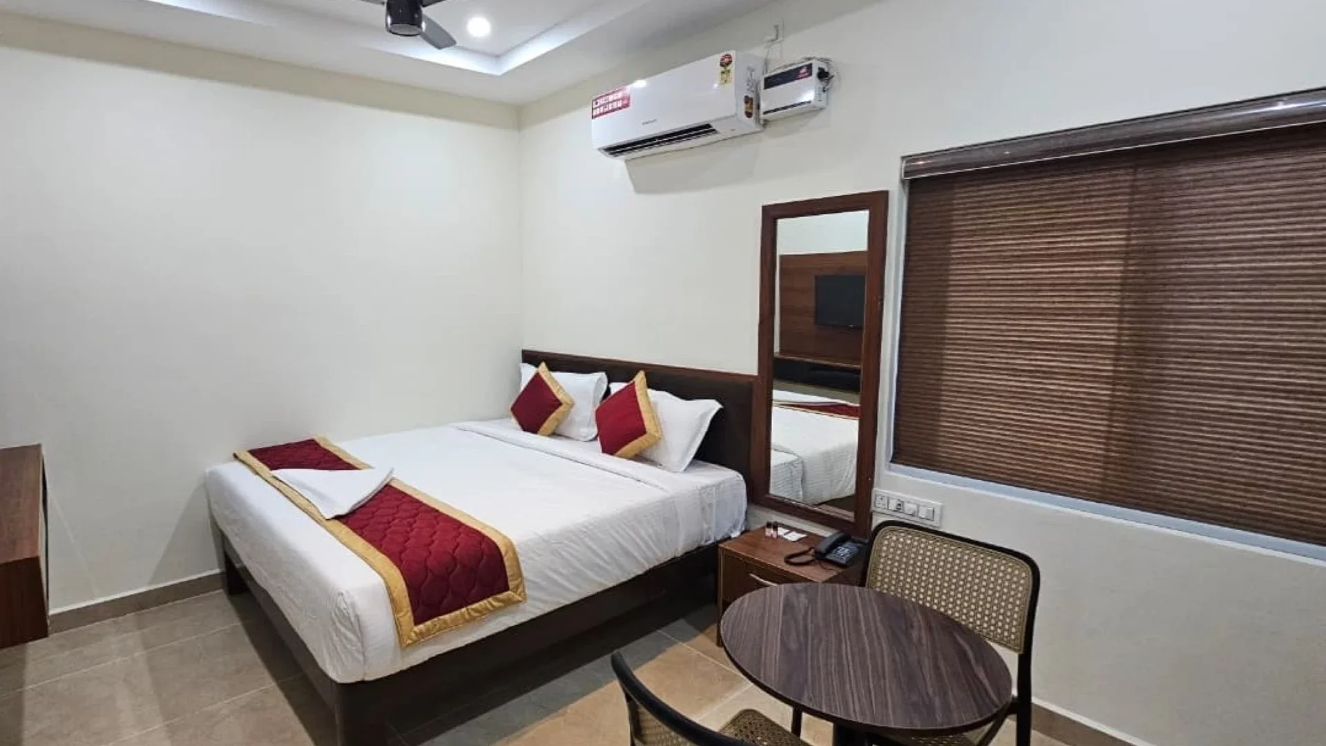 Guest room with a double bed, air conditioning, mirror and seating table
