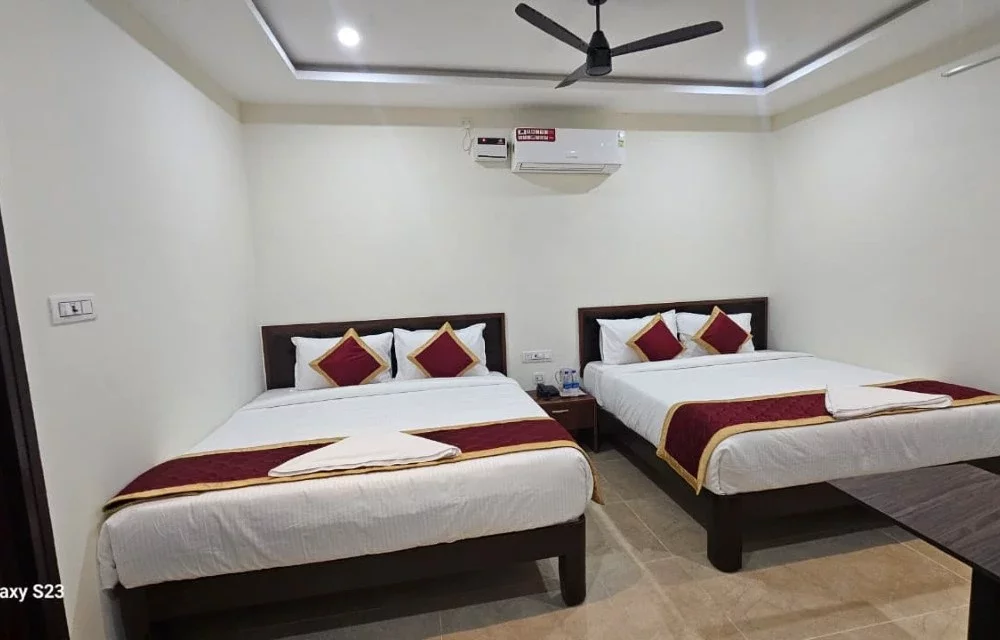 Front view of a larger guest room with two double beds